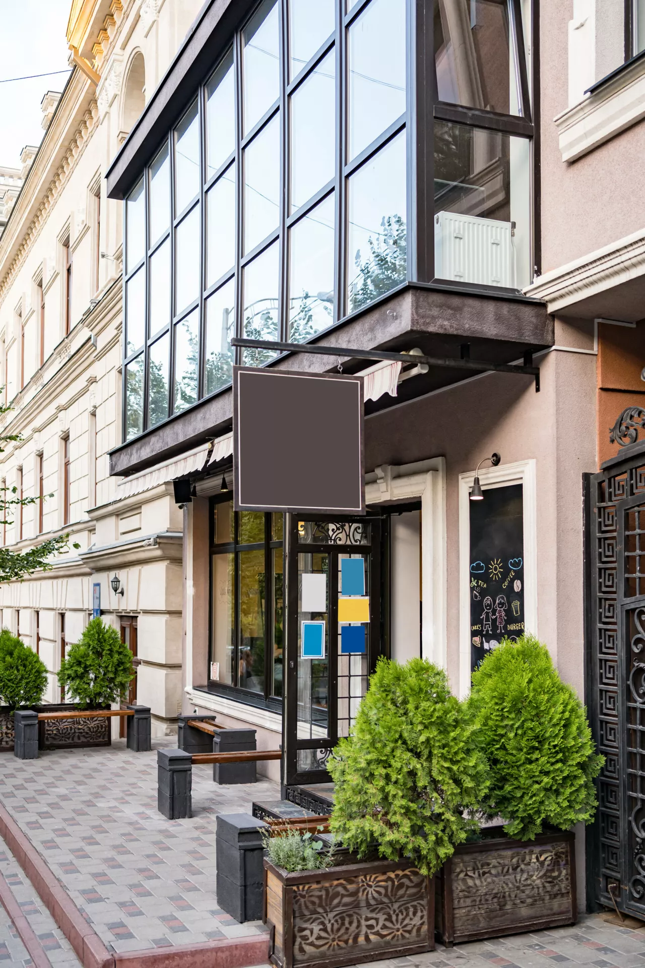 Façade de restaurant avec terrasse vide et enseigne vierge.